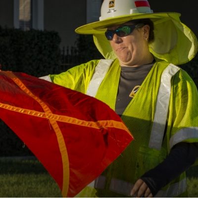 Michigan Asphalt and Sealcoating Worker in Michigan with safety gear and a caution flag